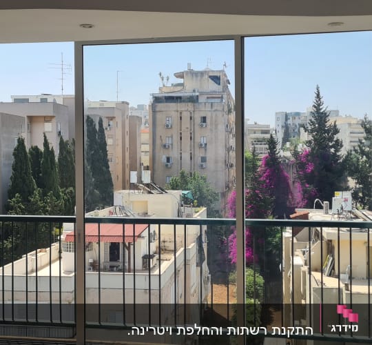 חלון אלומיניום עם נוף עירוני ברקע